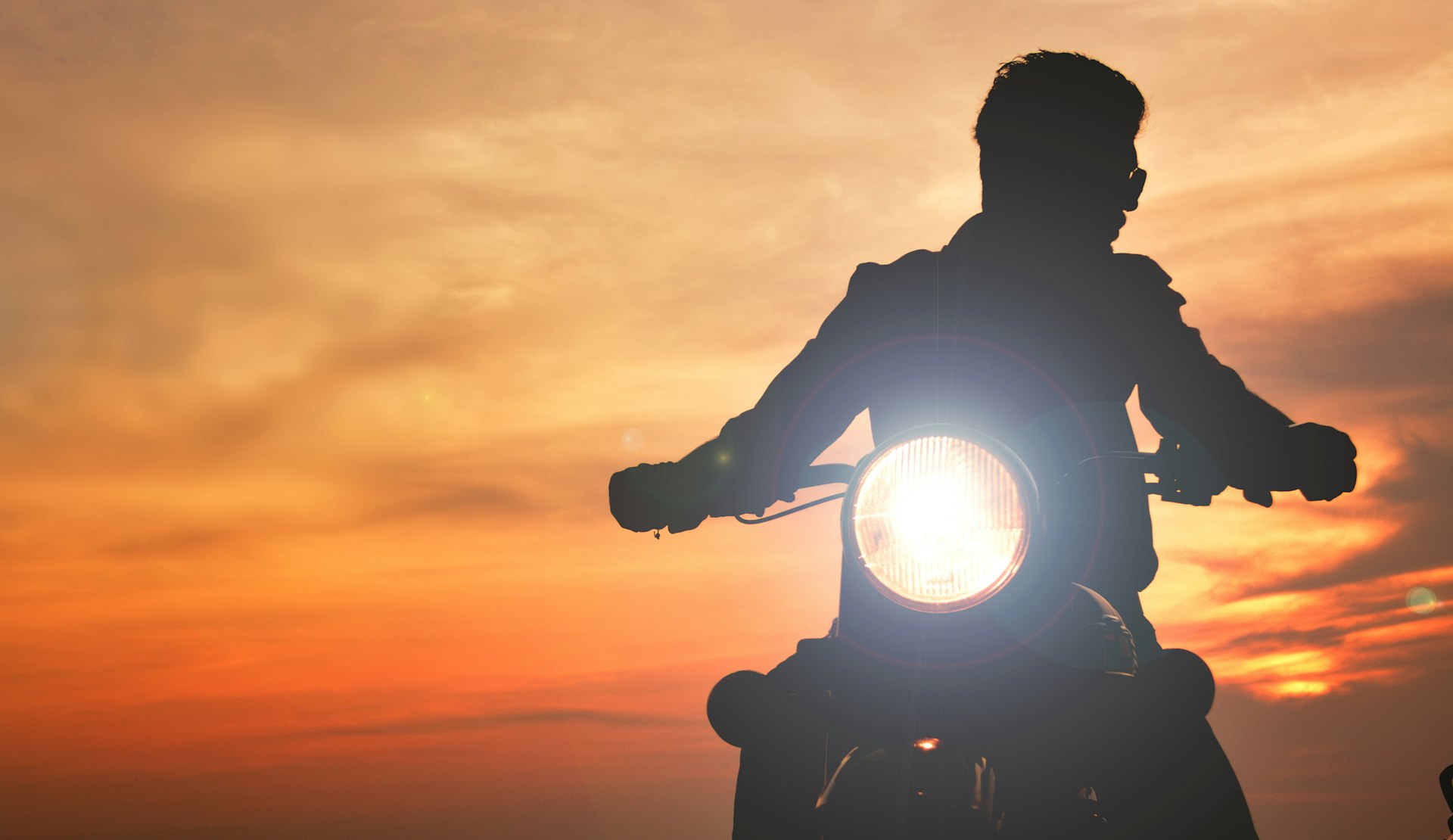Motorbike rider on the road at sunset